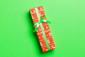geschenk doos met groen boog voor Kerstmis of nieuw jaar dag Aan groen achtergrond, top visie met kopiëren ruimte foto