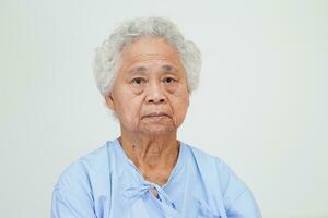 Aziatische oudere senior vrouw patiënt zittend op bed in het ziekenhuis, close-up bij haar hand. foto