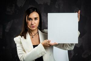 een bedrijf vrouw houdt een leeg teken in voorkant van de camera. foto