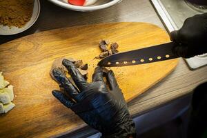 vrouw Koken smakelijk gesmolten chocola Aan tafel in keuken. foto