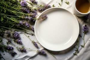 een wit bord, een kop met heet koffie en een boeket van Purper lavendel bloemen Aan een wit tafelkleed. een symbool van ontspanning, waardering van gemakkelijk genoegens en de schoonheid van natuur. ai gegenereerd. foto