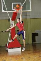 een Mens is jumping omhoog naar dunk een basketbal foto