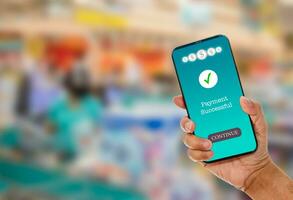 een man's hand- houdt een smartphone Aan scherm met bericht betaling geslaagd in een supermarkt. concept van financieel transacties met mobiel apparaten. detailopname, geld, overdracht, online. wazig achtergrond foto