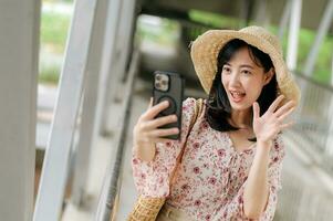 jong Aziatisch vrouw reiziger met het weven mand selfie met mobiel telefoon en staand Aan viaduct. reis reis levensstijl, wereld reizen ontdekkingsreiziger of Azië zomer toerisme concept. foto