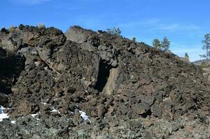 klein berg van zwart lava rots formaties foto