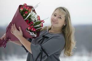 gelukkig vrouw met een boeket van bloemen foto