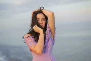 jong gewoon meisje van model- uiterlijk poseren tegen de achtergrond van de zee en lucht foto