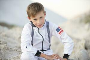 een knap jongen gekleed net zo een Amerikaans astronaut glimlacht en looks in de camera. foto