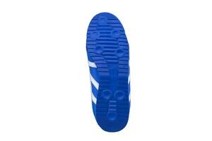 blauw rubber zool met sportschoenen Aan een wit achtergrond. foto