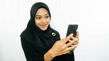vrolijk jong Aziatisch vrouw nemen selfie, kijken smartphone voorkant camera geïsoleerd over- wit achtergrond foto
