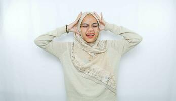 jong mooi Aziatisch moslim vrouw vervelend een hoofddoek geschreeuw en schreeuwen luid met een hand- Aan haar mond. communicatie concept. foto
