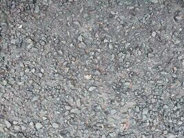 asfalt ruw en rotsachtig grunge oppervlak, structuur achtergrond, grijs geplaveid weg foto