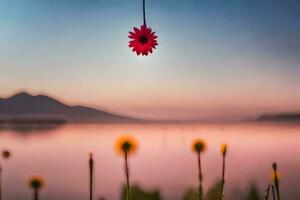 een rood bloem hangende van een draad over- een meer. ai-gegenereerd foto