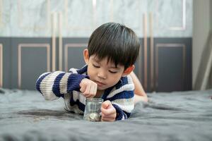 Aziatisch jongen gelukkig tellen munten naar opslaan geld foto