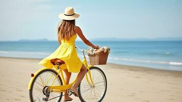 jong zorgeloos vrouw in helder geel jurk met fiets Bij oceaan strand. generatief ai foto