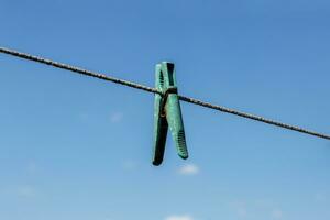 wasknijper hangende Aan een Kledinglijn met blauw lucht foto