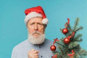 boos verdrietig de kerstman bang maken kinderen, Mens draagt de kerstman hoed tonen agressief emoties - negatief en slecht humeur Kerstmis concept foto