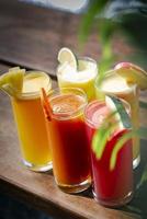 gemengde verse biologische vruchtensap glazen selectie op zonnige tuintafel foto