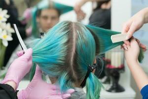 twee kappers kammen klanten haar- voordat haar- verven werkwijze. terug visie van vrouw hoofd met smaragd haar- kleur en opnieuw gegroeid haar- wortels foto