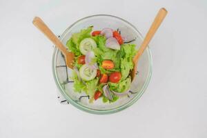 Koken - vrouw maken vers biologisch groente salade in de keuken. vrouw handen voorbereidingen treffen heerlijk gezond voedsel Bij huis, menging groenten in een schaal, detailopname. foto