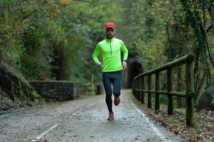 man atleet loopt op fietspad in de herfst foto