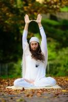 in het herfstpark beoefent een jonge vrouw alleen yoga foto