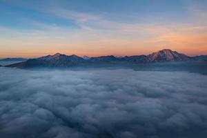 bergen ontspruiten uit lage wolken foto