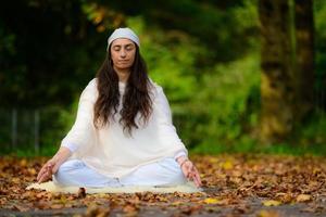 yogabeoefening in het herfstpark door een meisje foto