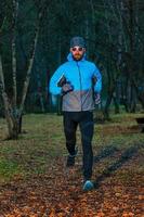 jonge man atleet tijdens een run in het bos foto