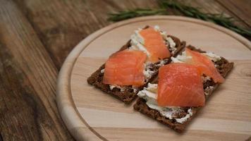 broodjes met zalm op houten snijplank foto