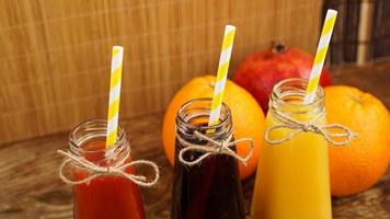 zelfgemaakte limonade in kleine flesjes. veelkleurige sappen en fruit foto