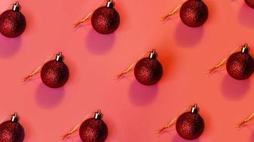 rode kerstballen in rijen op een roze achtergrond foto