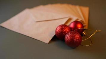 kerst compositie. ambachtelijke enveloppen en rode ballen foto