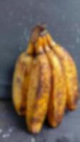 vervaag foto van rijp bananenfruit op gele en zwarte achtergrond