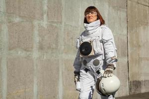 vrouw astronaut zonder helm op de achtergrond van een grijze muur foto