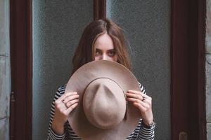 mooie vrouw in een gestreept shirt die haar hoed vasthoudt foto