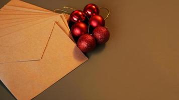 kerst compositie. ambachtelijke enveloppen en rode ballen foto