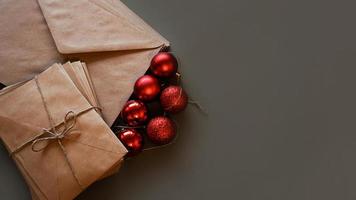 kerst compositie. ambachtelijke enveloppen en rode ballen