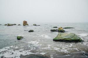 rotsen in de zee vroeg in de ochtend foto