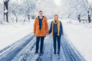 jongen en meisje lopen en hebben plezier in het bos in de winter foto