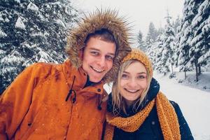 jongen en meisje lopen en hebben plezier in het bos in de winter foto