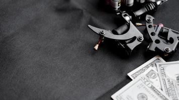 tattoo-machines op een zwarte achtergrond en dollars. tattoo kunst concept foto