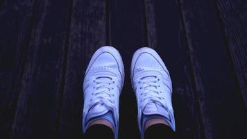mode hipster coole vrouw met witte sneakers, vintage getinte kleuren foto