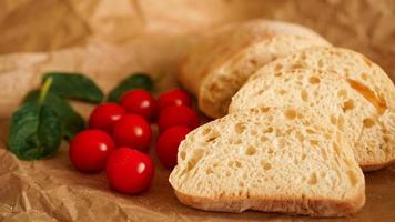 ciabatta plakjes en cherrytomaatjes op ambachtelijk papier. foto