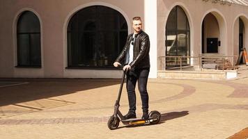 moderne man rijdt op een elektrische scooter in de stad foto