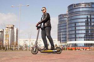 moderne man rijdt op een elektrische scooter in de stad foto