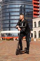 innovatief vervoer. blije optimistische man leunend op elektrische scooter foto