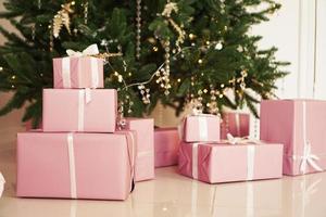 roze cadeaudoosjes met linten onder de kerstboom foto