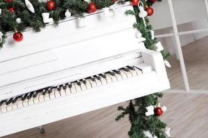 toetsen op witte buffetpiano met kerstdecor foto