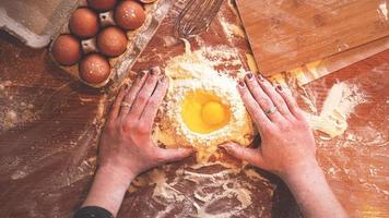 professionele vrouwelijke bakker kookdeeg met eieren en bloem foto